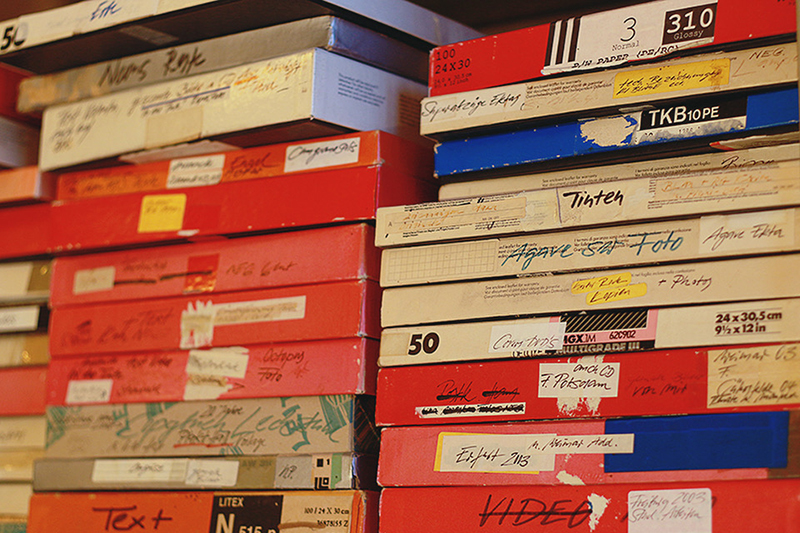 stacks of red white and blue photo boxes lined on a shelf, showing hanna frenzel's archival practice